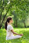 Young girl in lotus pose outdoors