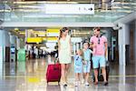 Family with children with a suitcase at the airport