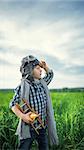 Little boy with airplane in the field