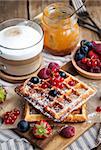 Belgian waffles with fresh berries and cappuccino coffee for breakfast