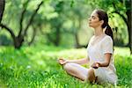 Young girl in lotus pose in the park