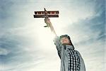 Boy with wooden airplane in the field