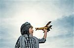 Boy with wooden airplane outdoors