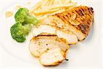 Grilled chicken with french fries and broccoli close up