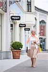 Elderly woman with shopping bags outdoors