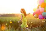 Little girl with balloons in the field