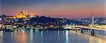 Panoramic image of Istanbul with Suleymaniye Mosque and Golden Horn Metro Bridge at sunset.