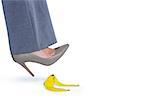 Woman with heel shoes walking on banana on white background