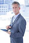 Businessman holding a tablet and looking at the camera in the office