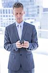 Businessman texting with his smartphone in the office