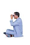 Businessman looking through binoculars on white background