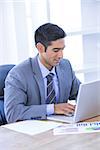 Businessman typing on his laptop in his office