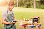 Handsome farmer using his tablet on a sunny day