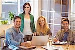 Group of young colleagues using laptop at office