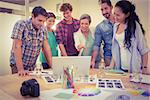 Happy creative business team using laptop in meeting at office