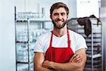 Handsome barista smiling at the camera at the cafe