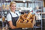 Pretty waitress carrying basket of bread at the bakery