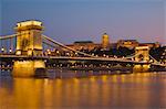 The Chain Bridge (Szechenyi Lanchid), over the River Danube, illuminated at sunset with the Hungarian National Gallery behind, UNESCO World Heritage Site, Budapest, Hungary, Europe