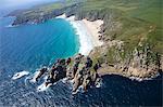 Aerial photo of Treen Cliff and Porthcurno beach looking west to the Minnack Theatre, West Penwith, Cornwall, England, United Kingdom, Europe