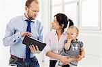 Couple with baby girl using digital tablet