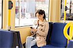 Woman using cellphone in tram