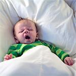 Yawning baby in bed