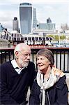 Senior couple, modern buildings on background