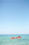 Woman floating in inflatable mattress