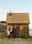 Happy couple near wooden house