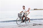 Couple cycling on beach