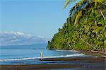 Central America, Costa Rica, Golfito, a young woman on a black sand beach in Piedras Blancas national park on the Golfo Dulce