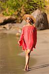 Dominica, St John Parish, Portsmouth, Secret Bay. A young lady walks along Secret Beach..