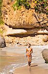 Dominica, St John Parish, Portsmouth, Secret Bay. A young lady runs along Secret Beach..