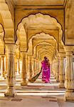 India, Rajasthan, Jaipur, Amer.  A Rajasthani woman in bright clothing sweeps the floor of a beautiful pavilion in the magnificent 16th century Amber Fort.