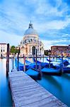 Italy, Veneto, Venice. Wooden jetty and gondolas moored on the Gran Canal overlooking Santa Maria della Salute.