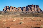 Jordan, Wadi Rum. An iconic desert landscape in Wadi Rum with the dramatic Jebel Qatar Mountain range in the distance.