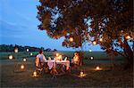 Kenya, Mara North Conservancy. A couple enjoy a romantic dinner overlooking the Mara.