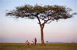 Kenya, Mara North Conservancy. A couple enjoy a sundowner on the plains of the Mara North Conservancy.