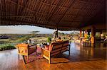 Kenya, Amboseli, Tortilis Camp. A man looks out over Kilimanjaro from a luxury room.