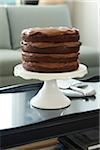 Layered Chocolate Birthday Cake on Cake Stand on Coffee Table