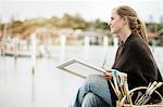 Young woman painting at sea