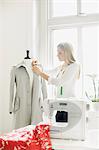 Woman preparing coat on mannequin