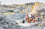 Family playing cards on rocks