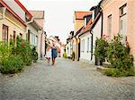 Mother with daughter walking through quiet street