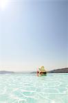 Woman with cocktail in swimming-pool