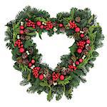 Heart shaped christmas wreath with red bauble decorations, holly, mistletoe, ivy and winter greenery over white background.