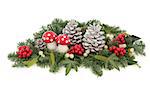 Christmas decoration with fly agaric mushroom bauble, holly, mistletoe, ivy, pine cones and traditional winter greenery over white background.