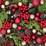 Christmas abstract background with red bauble decorations, holly, ivy, mistletoe, blue spruce fir and cedar cypress greenery.