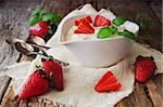 yogurt in a bowl and ripe strawberries on a wooden background. useful dessert.health and diet food. selective focus