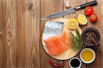 Salmon, spices and condiments on wooden table. Top view with copy space